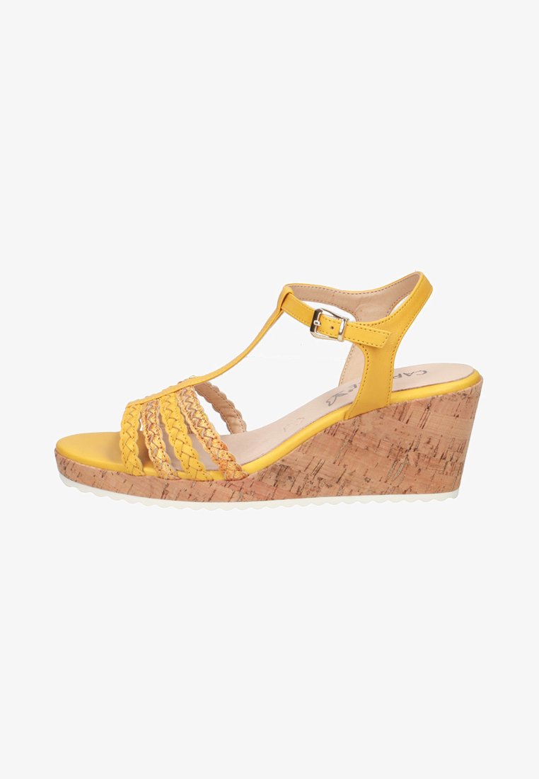 Yellow wedge sandals with braided straps, cork-textured sole, and an ankle buckle. Features a smooth footbed and rubber outsole.