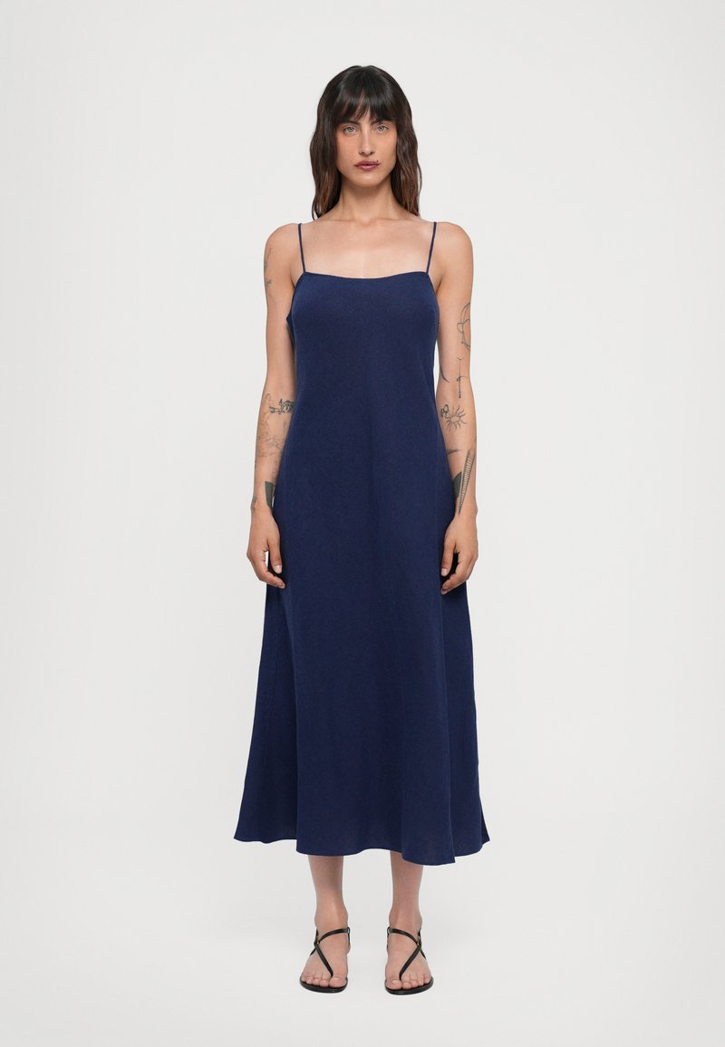 Vestido de tirantes finos en azul marino, con forma A-line que fluye y longitud a mitad de pantorrilla, hecho de una tela ligera con una textura suave.