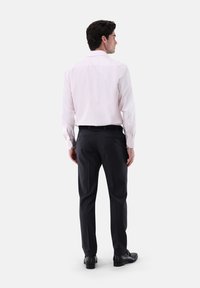 Helles rosa Langarmhemd mit klassischem Kragen, kombiniert mit dunkelblauen, maßgeschneiderten Hosen und schwarzen Schuhen, von hinten betrachtet.