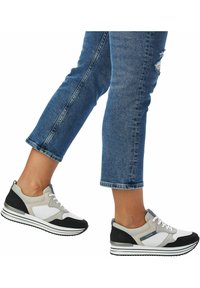 Sportiga sneakers med ett överdel i mesh och syntetmaterial i grått, vitt och svart, med en dämpad sula och vita rand-accenter.