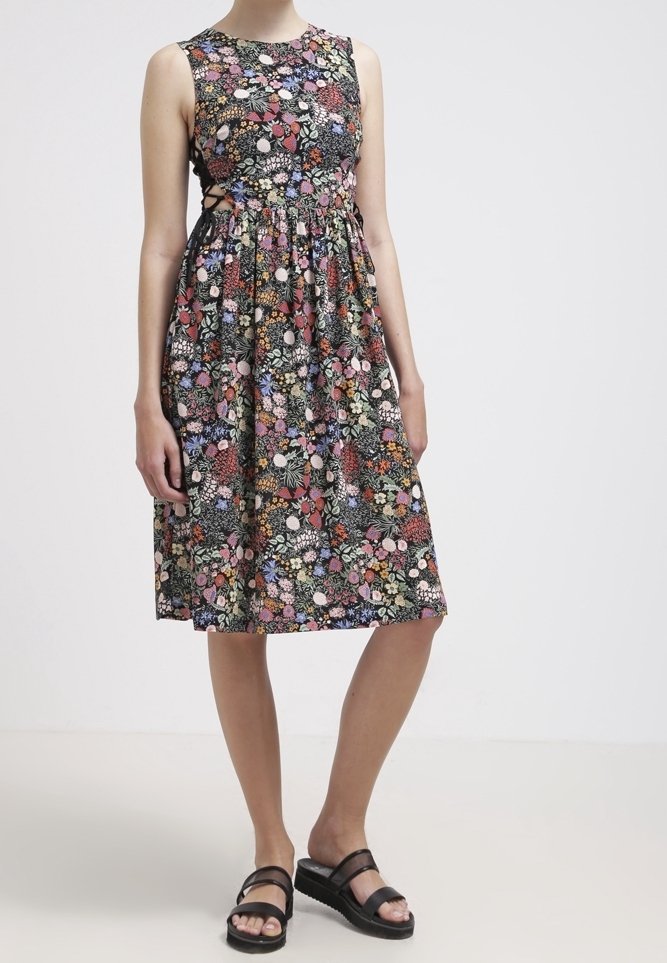 Blumenkleid mit schwarzem Hintergrund; verfügt über bunte Blumenmuster, ärmelloses Design und eine taillierte Taille mit einem ausgestellten Rock.