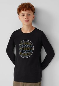 Zwarte lange mouwen t-shirt met een cirkelvormige graphic waarin het woord "SOUND" in verschillende lettertypen en kleuren is afgebeeld. Zachte stof met een gladde textuur.