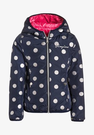 Marineblå polstret jakke med store sølvfarvede prikker, lynlås foran og pink foring. Har hætte og elastiske manchetter for en tætsiddende pasform.