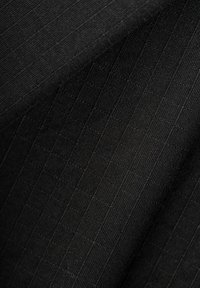 Schwarzer Stoff mit einem strukturierten Muster, das Gitterlinien zeigt, in mittlerem Gewicht und mit glatter Oberfläche.