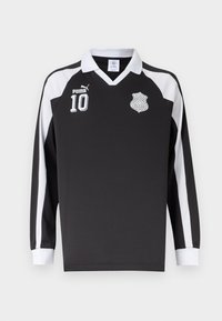 Črna športna majica z dolgimi rokavi z belim ovratnikom, belimi črtami na rokavih, logotipom Puma, številko 10 in keltskim vozel emblemom na prsih.