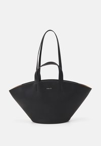 Sac fourre-tout noir à la forme large et angulaire, fabriqué en matériau lisse. Il possède deux longues poignées et un logo subtil à l'avant.
