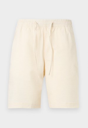 Κρεμ casual σορτς με διακριτικές κάθετες ρίγες, ελαστική μέση και μπροστινό κορδόνι σε απλό ανοιχτό φόντο.