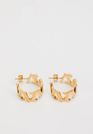 Goldene Creolen mit einem einzigartigen durchbrochenen Design und scharfen, kantigen Formen. Die Oberfläche ist glatt und glänzend, was einen markanten Look erzeugt.