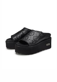 Sandali con platform neri e superiore perforato, dotati di una suola testurizzata e dettagli decorativi con cuciture.