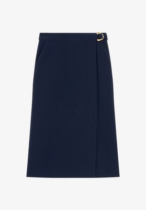 Marineblauwe kokerrok van textuurstof, met zijzakken en een gouden ringaccent op de tailleband. Rechte silhoët met een zoom boven de knie.
