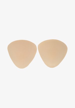 Een paar beige zelfklevende bh-inzetstukken met een glad oppervlak en afgeronde driehoekige vorm op een witte achtergrond.