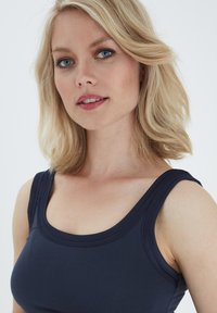 Top senza maniche blu navy con scollatura rotonda, spalline larghe e tessuto morbido. Presenta cuciture sottili lungo i bordi.