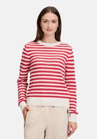 Rot-weiß gestreifter Pullover mit rundem Ausschnitt, gerippten Bündchen und Saum; aus Strickstoff gefertigt, mit lockerem Sitz und strukturierter Gestaltung.