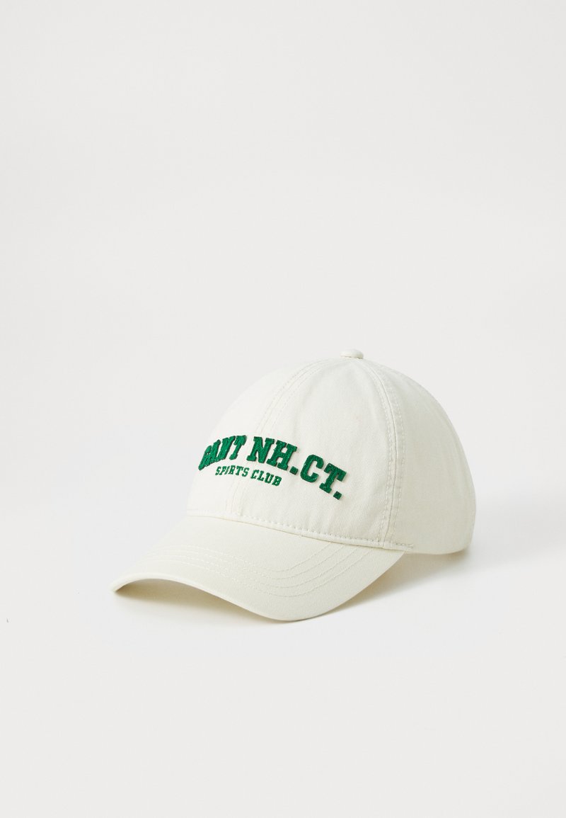 Baseball cap in cream fabric, featuring green embroidered text “Navy NH CT. Sports Club” on the front. Curved visor and stitched panels.