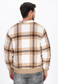 Braun-, Beige- und Weißkariertes Flanelljackett mit weicher Textur, langen Ärmeln und gerippten Bündchen. Gerade geschnitten und klassisches Kragen-Design.