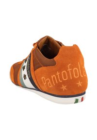 Sneaker arancione in suede con elementi in rete, stelle decorative e branding. Suola bianca con accenti verdi, bianchi e rossi sul tallone.