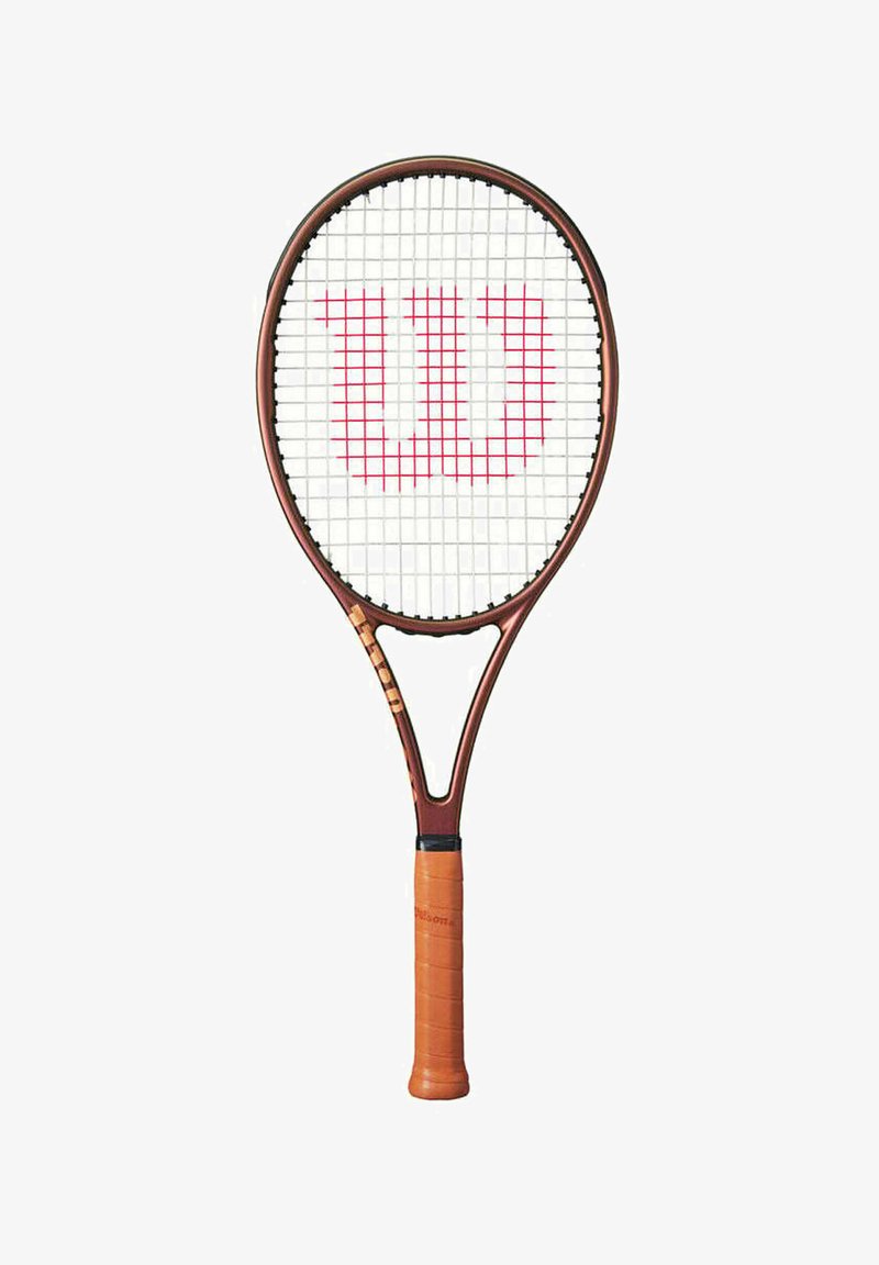 Raquette de tennis Wilson avec un cadre marron, une prise orange, des cordes blanches et un logo "W" rouge au centre. Présente une forme ovale classique.