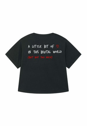 T-shirt noir oversize avec du texte manuscrit blanc et rouge : "Un peu de ❤️ dans ce monde brutal (MAIS PAS TROP)."