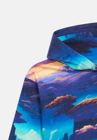 Φούτερ με έντονο εκτυπωμένο σχέδιο ουρανού σε γκριάντι, που περιλαμβάνει σύννεφα, χρώματα ηλιοβασιλέματος και αφηρημένες σιλουέτες βουνών πάνω στο ύφασμα.