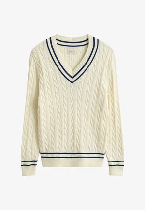 Suéter de punto con cuello en V color crema con rayas azul marino en el cuello, los puños y el dobladillo, con textura acanalada.