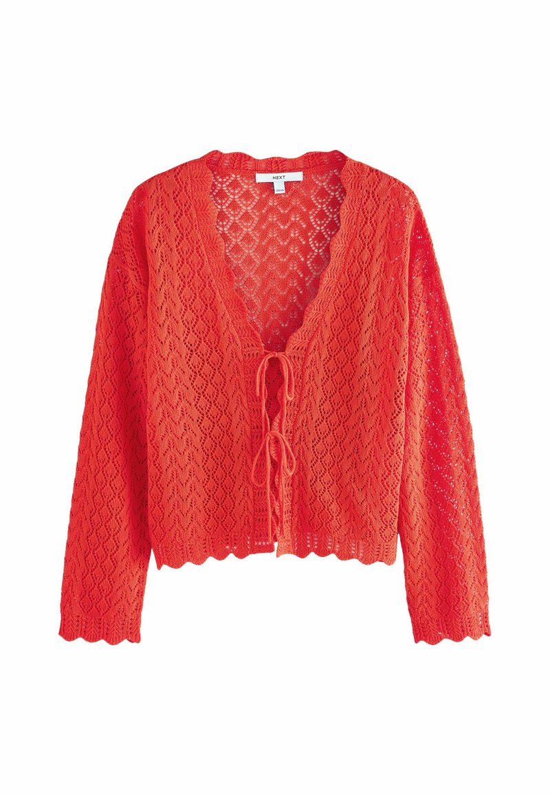 Cardigan en dentelle rouge avec des manches longues, décolleté en V et fermeture à nouer à l'avant. Ourlet à volants et motif en diamant délicat sur l'ensemble. Texture légère.
