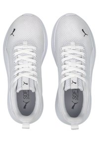 Hvite joggesko med mesh-overdel, flate hvite snøringer og grå innside. Har en svart logoakcent på sidene og tungen.