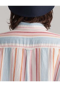 Stribet skjorte med knapper, der har blå, pink, orange og hvide striber, lavet af letvægtsstof med klassisk krave og rygfold.