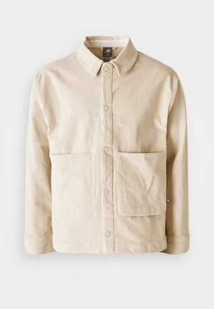 Beige corduroy jacket with a collar, front snap buttons, and two large front pockets, displayed flat on a white background.