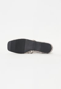 Sandal med slangeskinnsprint og teksturert overdel, sort gummisåle og flat utførelse. Har en tåstropp for sikker passform.