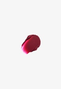 Tache de rouge à lèvres rouge profond sur fond blanc avec une texture brillante et des bords légèrement irréguliers.