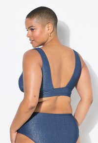 Set bikini blu denim con finitura testurizzata. Presenta un top con scollatura a V profonda e un fondo a vita alta, che offre una silhouette fluida.