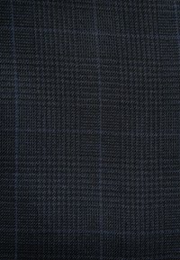 Tissu en bleu foncé avec un motif à carreaux subtil. La texture est lisse, tricotée et étroitement tissée, ce qui augmente sa durabilité.