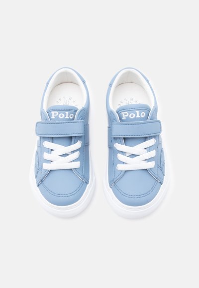 Φωτεινά γαλάζια αθλητικά παπούτσια Polo με λευκά κορδόνια, λουράκι βέλκρο στο πάνω μέρος και λευκές σόλες, φτιαγμένα από ψηλά σε λευκό φόντο.