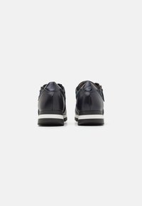 Sneakers in pelle blu navy con una texture liscia, suola in gomma bianca e accenti posteriori a contrasto. Dotati di doppie cerniere laterali per una facile vestibilità.