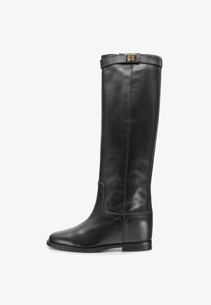 Stivale da equitazione alto in pelle nera con suola piatta e cinturino decorativo con fibbia dorata nella parte superiore.