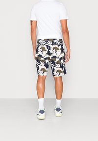 Shorts pour hommes de couleur marine avec un motif de feuilles crème et olive, confectionnés en tissu léger avec des poches latérales et une coupe décontractée.