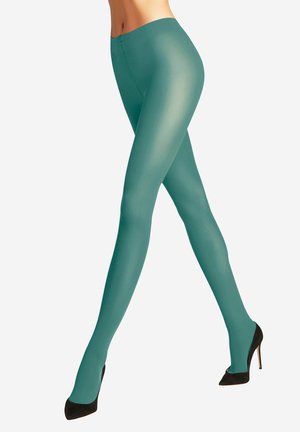 Türkise Leggings mit glattem, glänzendem Finish. Hoher Taillenbund und taillierter Schnitt. Getragen mit schwarzen High Heels, die die Beine betonen.