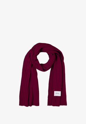 Dumon valkoinen huivi, joka on valmistettu pehmeästä kankaasta, jossa on uritettu burgundinpunainen väri, suorakaiteen muotoinen ja yhdellä päällä valkoinen etiketti mustalla tekstillä.