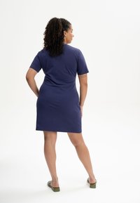 Korte mouw navy jurk gemaakt van zachte stof, getailleerde snit, knielengte, met een schone zoom en eenvoudig ontwerp.