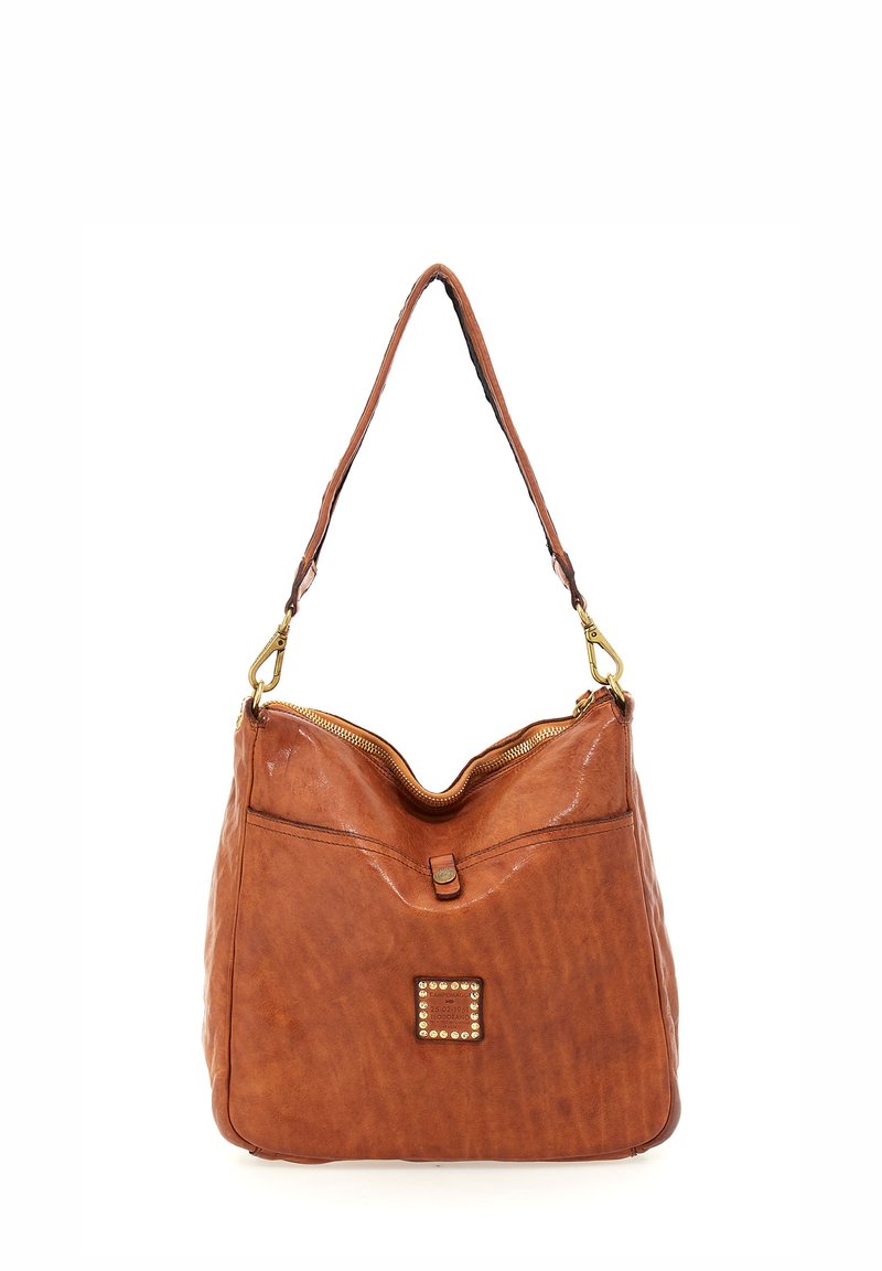 Borsa a spalla in pelle color cammello con chiusura a zip, parte superiore curva e pannello decorativo con borchie sul davanti. Presenta una tracolla singola e una superficie liscia.