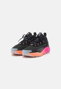 Scarpe sportive nere con una parte superiore texturizzata, caratterizzate da accenti arancioni e rosa sulla suola e lacci neri. Design leggero con caratteristiche di supporto.