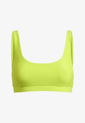 Erks kollane spordirinnahoidja laiade õlapaelte ja ruudukujulise lõikega, mõeldud sportimiseks.