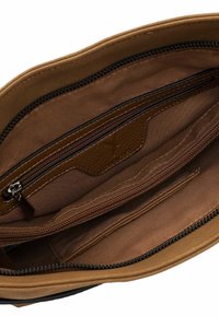 Brown fabric handbag interior featuring one zipped pocket and multiple open compartments, with tan accents and smooth texture.
