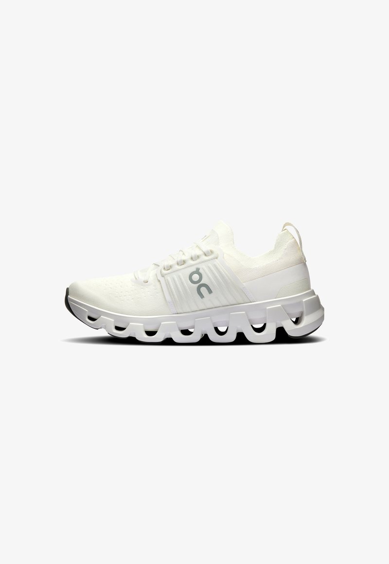 Weiße Sportschuhe mit einer strukturierten Oberseite, Schnürverschluss und einer markanten segmentierten Sohle für Flexibilität und Dämpfung.