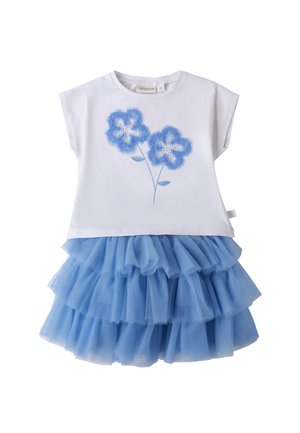 Top in cotone bianco con design floreale blu, abbinato a una gonna in tulle blu a più strati. La gonna presenta una texture arricciata e più livelli.