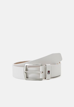 Ceinture en cuir blanc avec une boucle en métal argenté, ornée d'un petit logo. Texture lisse avec un design classique.