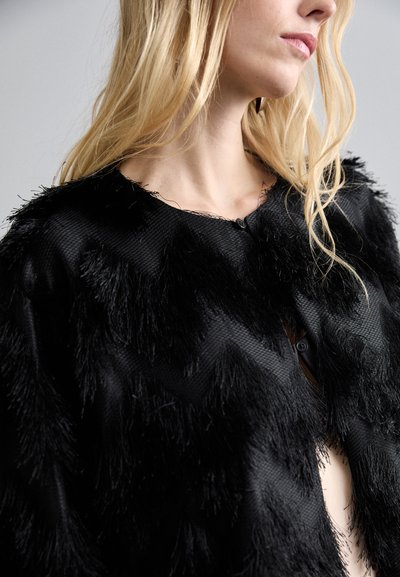 Melna saīsināta kardigāna jaka, kas izceļas ar strukturētu audumu ar pušķu detaļām, pogu aizdari un apaļu kakla izgriezumu.