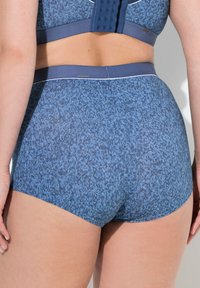 Modré sportovní šortky vyrobené z texturované látky, mají tvar s mírným zúžením, jemný vzor a elastický pas.