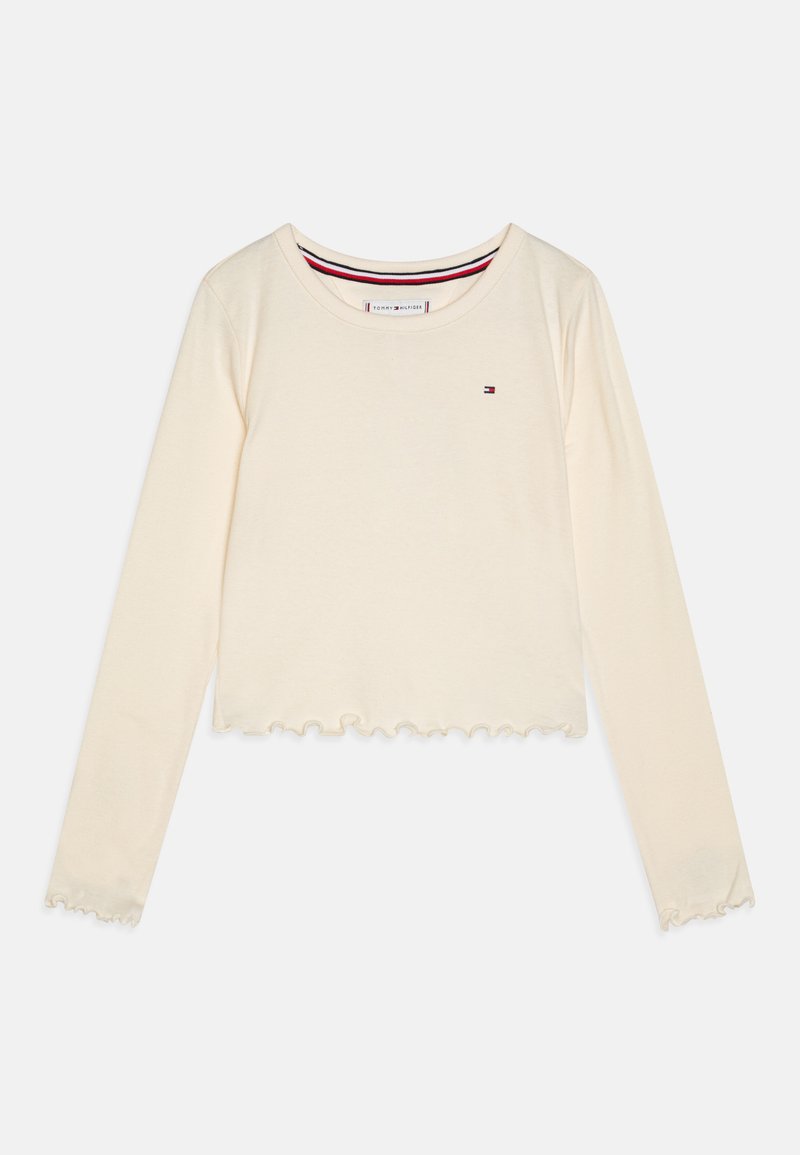 Cremefarvet langærmet skjorte lavet af blødt stof, med rund halsudskæring, flæset kant og et lille logo på fronten.