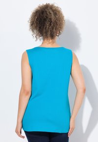Top senza maniche in turchese brillante, realizzato in tessuto liscio. Collo rotondo e vestibilità comoda, con un orlo posteriore leggermente allungato.
